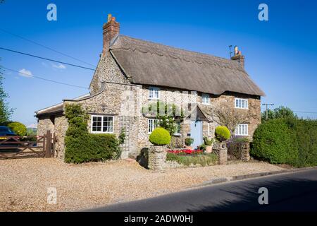 Un grazioso staccato cottage con il tetto di paglia sulla roadsise attraverso Sandy Lane village nella parrocchia di Bromham e Chittoe Wiltshire, Inghilterra REGNO UNITO Foto Stock