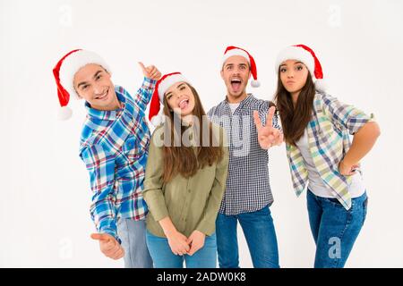 Gruppo di simpatici giovani in cappelli di Babbo Natale celebrare il Natale Foto Stock