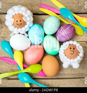 Pasqua flatlay, cucchiai, tinte colorate le uova e carne di agnello figure sagomate sul tavolo di legno Foto Stock