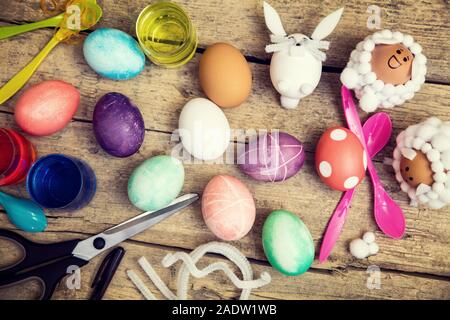 Flatlay, craft idee e materiali per il tempo pasquale, uova, coloranti e altre decorazioni sul tavolo di legno Foto Stock