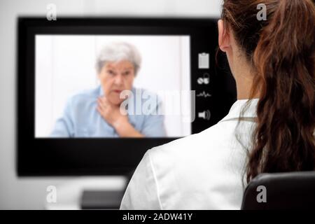 Donna anziana con dispnea, Dottore guardando la scrivania, telemedicina e telesanità con live chat Foto Stock