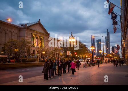 Le persone in coda per un bus su South Michigan Ave di fronte al Chicago Institute of Art, Chicago, Illinois, Stati Uniti d'America Foto Stock