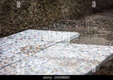 Fresca di cui lavato le lastre di cemento nell'area esterna, solette nel letto di ghiaia Foto Stock