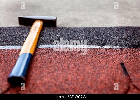 Il bitume di tegole con il martello e il tetto dei perni di cartone Foto Stock