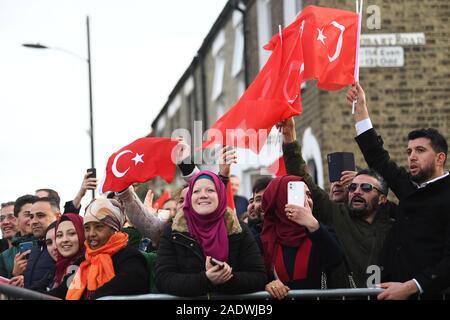 I membri del pubblico wave flags come presidente della Turchia Recep Tayyip Erdogan, arriva dal corteo di automobili per frequentare l'apertura ufficiale della nuova Cambridge Moschea centrale, in Cambridge. Foto Stock