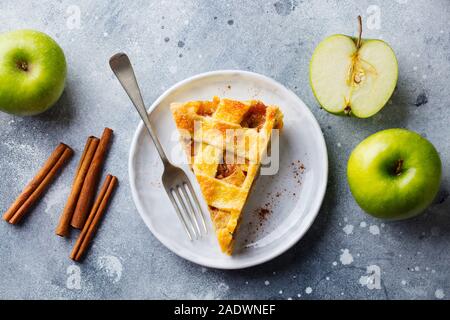 Torta di mele con caramello su una piastra bianca. Sfondo grigio. Vista superiore Foto Stock