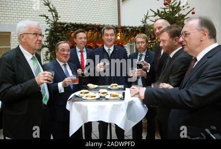 05 dicembre 2019, Berlin: Winfried Kretschmann (Bündnis 90/Die Grünen, l-r), il primo ministro del Land Baden-Württemberg, Armin Laschet (CDU), il primo ministro del Land Renania settentrionale-Vestfalia, Tobias Hans (CDU), il primo ministro del Land Saarland, Markus Söder (CSU), il Primo Ministro della Baviera, sono in accordo con Nürnberger Rostbratwürstel e Glühwein, Daniel Günther (CDU), il primo ministro del Land Schleswig-Holstein, Dietmar Woidke (SPD), il primo ministro del Land di Brandeburgo, Michael Kretschmer (CDU), il primo ministro del Land di Sassonia e Reiner Haselhoff (CDU), il primo ministro del Land Sassonia-Anhalt, presso il Ministro Presidente del turch Foto Stock