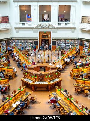 Centrale di palco in legno e tabelle piena di studenti che studiano in La Trobe Sala Lettura della Biblioteca di Stato di Melbourne Victoria Australia. Foto Stock