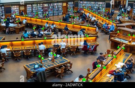 Tavoli in legno pieno di studenti che studiano in La Trobe Sala Lettura della Biblioteca di Stato di Melbourne Victoria Australia. Foto Stock