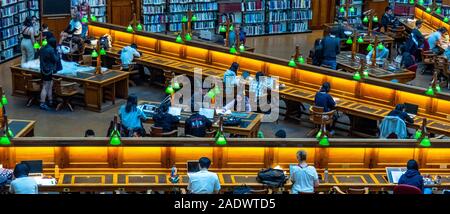 Tavoli in legno pieno di studenti che studiano in La Trobe Sala Lettura della Biblioteca di Stato di Melbourne Victoria Australia. Foto Stock