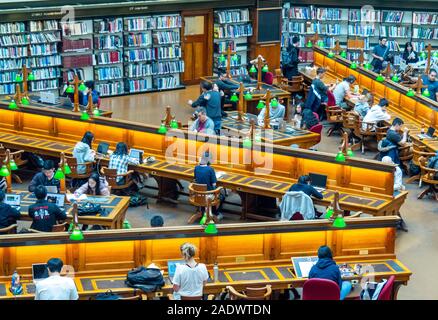 Tavoli in legno pieno di studenti che studiano in La Trobe Sala Lettura della Biblioteca di Stato di Melbourne Victoria Australia. Foto Stock