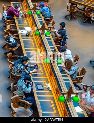 Tavoli in legno pieno di studenti che studiano in La Trobe Sala Lettura della Biblioteca di Stato di Melbourne Victoria Australia. Foto Stock