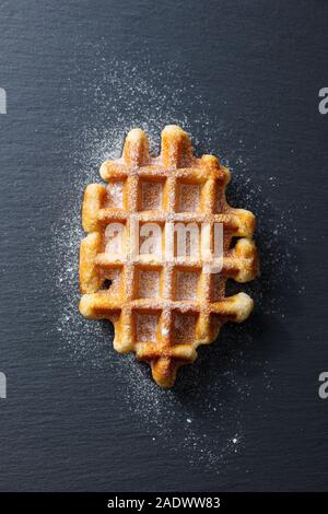 I waffle belgi con zucchero a velo. Sfondo di ardesia. Vista superiore Foto Stock