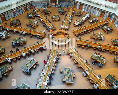 Tavoli in legno pieno di studenti che studiano in La Trobe Sala Lettura della Biblioteca di Stato di Melbourne Victoria Australia. Foto Stock