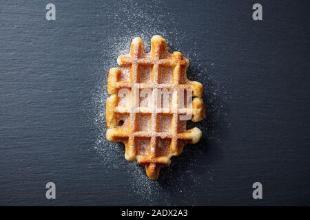 I waffle belgi con zucchero a velo. Sfondo di ardesia. Vista superiore Foto Stock