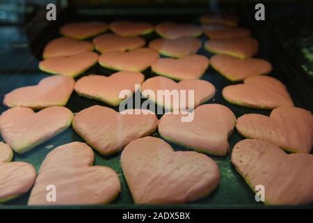 Vassoio da forno del pane appena sfornato zucchero biscotti frollini smerigliati con glassa rosa Foto Stock