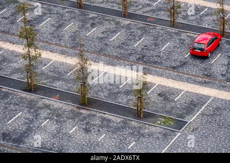 Vista aerea di una singola automobile rossa parcheggiata su un vuoto di parcheggio Foto Stock