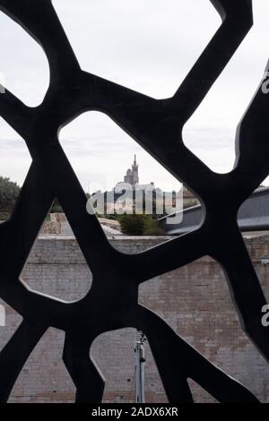 Il Notre Dame de la Garde Basilica come visto attraverso l'esterno della struttura in acciaio del MUCEM museum a Marsiglia, in Francia, in Europa Foto Stock