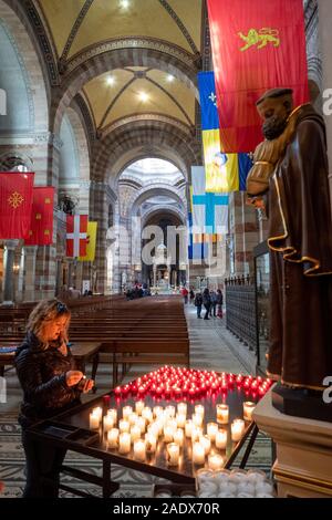 Donna accendere una candela in preghiera a San Antonio di Padova dentro la Cathédrale La Major - Cattedrale di Santa Maria Maggiore a Marsiglia, Francia Foto Stock