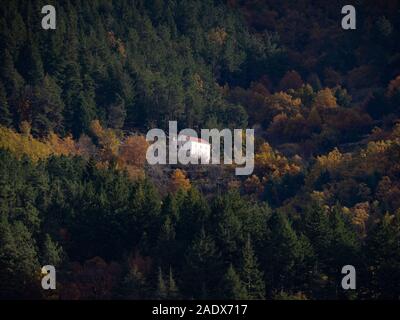 Casa isolata circondata da alberi in montagna campagna Foto Stock