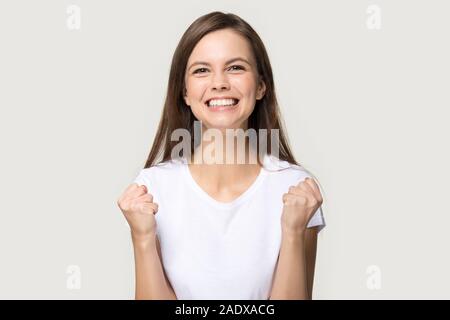 Eccitato giovane donna stringono i pugni in segno di vittoria Foto Stock