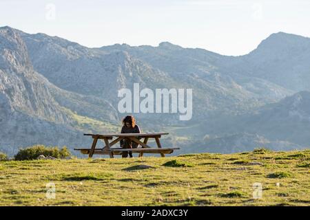 Donna che riposa su panchina in montagne spagnole, Sierra de camarolos, Andalusia, Spagna. Foto Stock