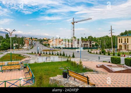 Penjikent Rudaki Avenue Ring Road ad alto angolo di visione con la guida di auto e persone a piedi su un nuvoloso cielo blu giorno Foto Stock