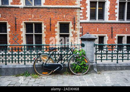 Vecchia bicicletta parcheggiata di fronte un cottage rustico Foto Stock