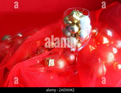 Rosso e oro sullo sfondo di Natale con la vigna di vetro e oro decorazioni di Natale all'interno. della vigna di vetro con decorazioni di Natale Foto Stock