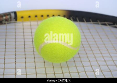 Parte della racchetta da tennis con soffici sfera gialla closeup Foto Stock