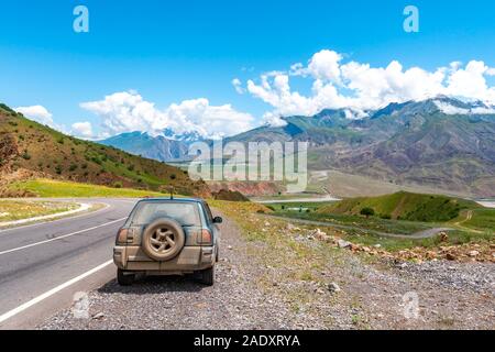 Per Kulob Qalai Khumb Pamir Highway pittoresco paesaggio mozzafiato vista di SUV Jeep a Panj lungo la valle del fiume su una soleggiata cielo blu giorno Foto Stock