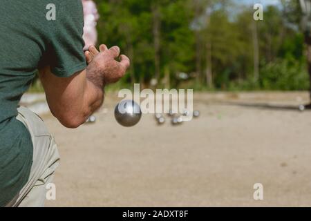 Senior persone preparate a buttare la palla di bocce in un parco in gioco all'aperto Foto Stock