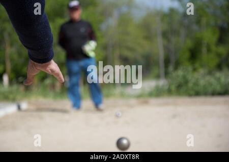 Senior persone preparate a buttare la palla di bocce in un parco in gioco all'aperto Foto Stock