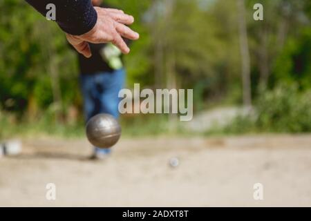 Senior persone preparate a buttare la palla di bocce in un parco in gioco all'aperto Foto Stock