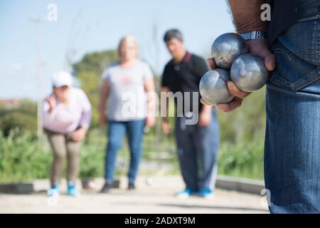 Senior persone preparate a buttare la palla di bocce in un parco in gioco all'aperto Foto Stock