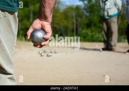 Senior persone preparate a buttare la palla di bocce in un parco in gioco all'aperto Foto Stock