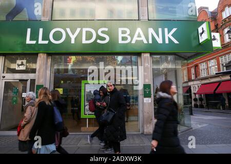 I membri del pubblico sono vedere a piedi passato Lloyds Bank nel West End di Londra. Foto Stock