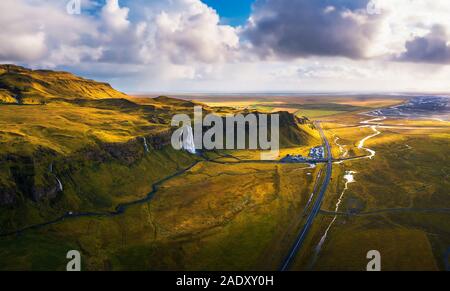 Vista aerea della cascata Seljalandsfoss, Seljalands river, cascata di parcheggio e la strada di circonvallazione in Islanda al tramonto. Foto Stock