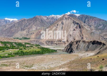 Qalai Khumb di Khorog Pamir Highway pittoresco Fiume Panj vista valle delle montagne su un soleggiato Blue Sky giorno Foto Stock