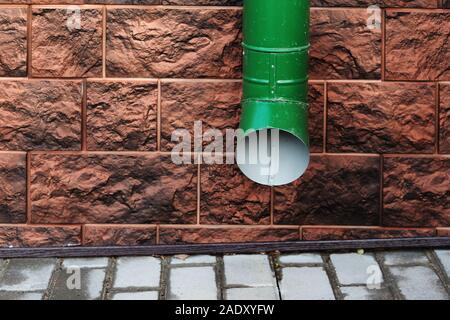 Il drenaggio d'acqua pluviale gronda su una parete marrone Foto Stock