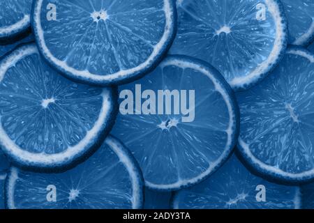 Close-up fette di agrumi sfondo astratto nel classico colore blu del 2020. Luminose texture alla moda. Foto Stock