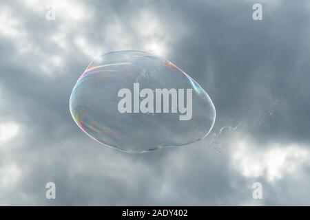 Una grande bolla di sapone di fronte parzialmente in cielo molto nuvoloso Foto Stock