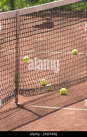 Molti giallo le palline da tennis su grounourt prima net vista laterale vista dettagliata Foto Stock