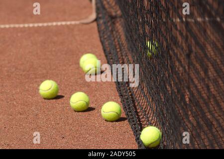 Molti giallo le palline da tennis su grounourt prima net vista laterale vista dettagliata Foto Stock