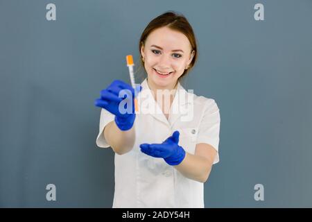 Sorridente bella donna dottore cosmetologo tenendo la siringa per iniezioni di bellezza. Cura della pelle, mesoterapia, spa Foto Stock