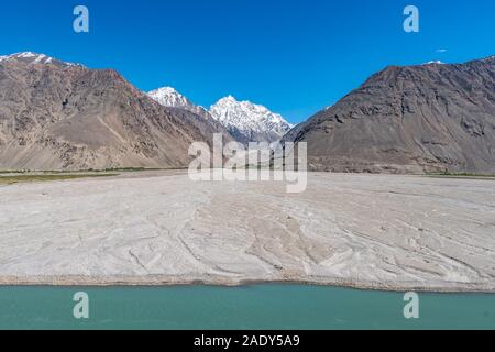 Pamir Highway Wakhan corridoio vista con Panj River Valley e Afghanistan montagne innevate su una soleggiata cielo blu giorno Foto Stock