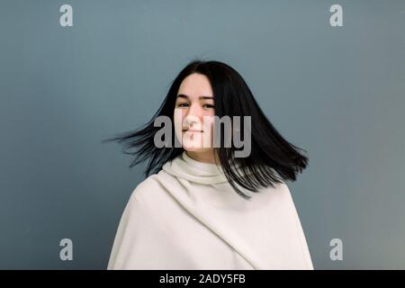 Giovane e bella bruna ragazza in movimento con una superficie perfettamente liscia capelli, dopo il trattamento in tricologia clinica. Bellezza viso, i capelli, cosmetologia. Isolato su Foto Stock