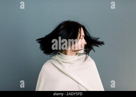 Giovane e bella bruna ragazza in movimento con una superficie perfettamente liscia capelli, dopo il trattamento in tricologia clinica. Bellezza viso, i capelli, cosmetologia. Isolato su Foto Stock