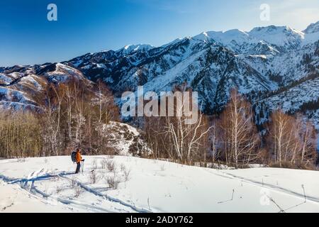 Un giovane uomo viaggi nelle montagne innevate in inverno con gli sci. Tour di sci. Foto Stock