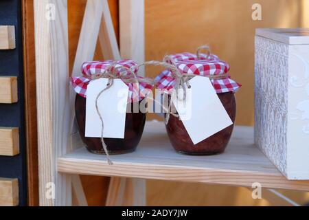 Vasi di vetro con red marmellata di frutti di bosco sono venduti nel negozio. Mock up per il titolo etichetta. Fermentato sano cibo vegetariano concetto. Foto Stock